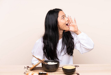 年轻亚洲女孩在吃亚裔食物时图片
