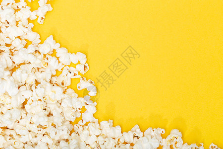 黄色背景上的爆米花电影或电视背景边框架顶视图片