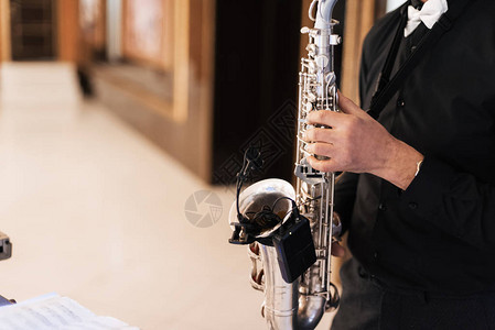一位男音乐家萨克斯管演奏家在节日活动中用萨克斯管演奏图片