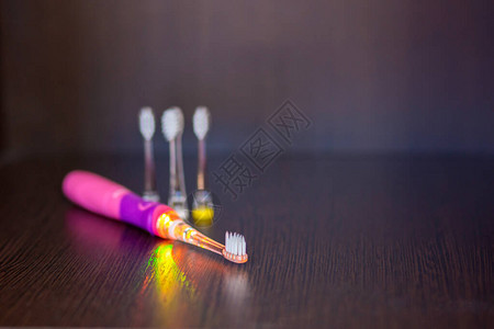 一个电池驱动的粉色电动粉红色牙刷装有三个可互换喷图片