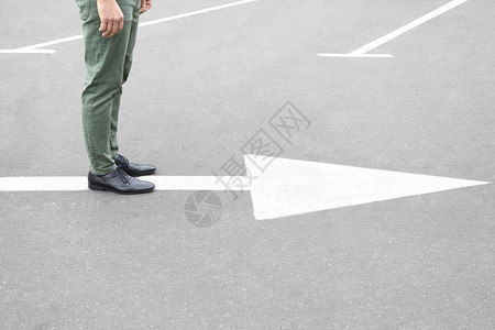 年轻人站在路上有箭头标记选择的概念图片