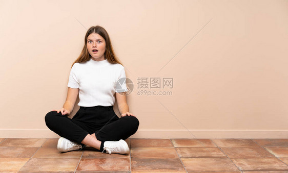 乌克兰少女坐在地板上面部表情令人惊讶图片