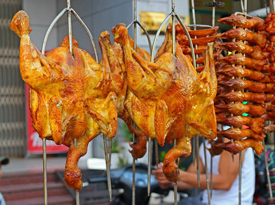 越南街头小贩柜台上的美味烤炸鸡背景图片
