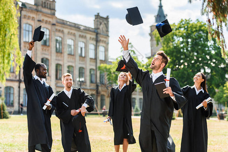 年轻快乐的毕业青年学生在大学花园里呕吐图片