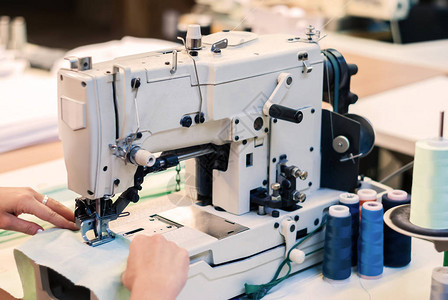 制衣厂的缝纫机和裁缝手掌上铺图片