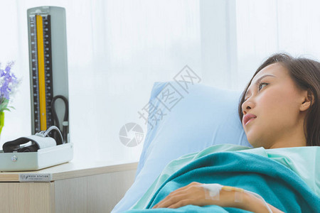 亚洲男医生用剪贴板检查躺在病床上的亚洲女病人的特写镜头图片