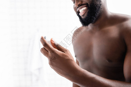 微笑的非洲裔美国人手里拿着除臭剂的剪影图片