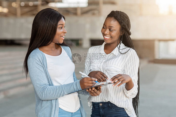 微笑的女面试官在街上对年轻的非洲裔美国图片