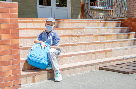 一个可爱的少年坐在学校的台阶上图片