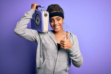 年轻的非洲裔美国黑人女孩在紫色背景下听着音乐图片