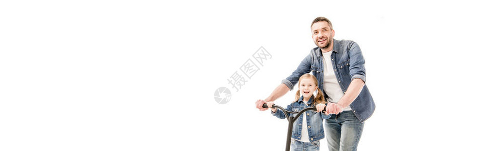 笑着的爸和女儿与滑脚车在图片