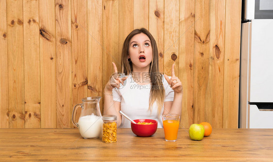 年轻金发美女吃早餐时用食指着食指图片