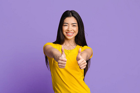 我喜欢它愉快的亚洲女孩用双手举过紫色工作室背图片