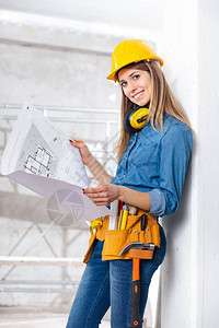 迷人的女建筑商或工程师在施工中的建筑工地站着图片