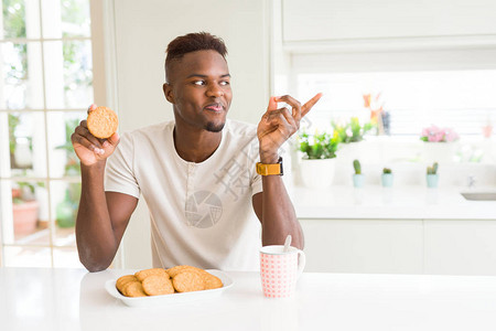 非裔美国人吃健康的全麦饼干非常快乐地用手和指对着另图片