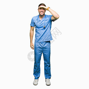 身穿医疗制服的帅男医生在孤立的背景中非常快乐图片