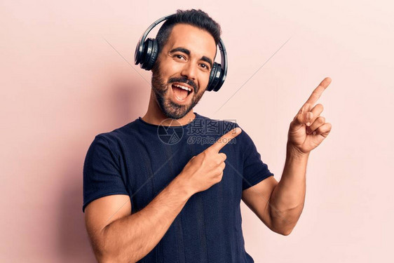 年轻的西班牙裔男子用耳机听音乐图片