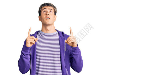 身穿紫色散漫运动衫的英俊男青年惊讶地仰望起来图片