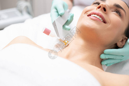 冷氧提升程序和金属工具触碰微笑女人颈部的紧贴相片图片