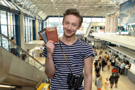 显示护照的可爱旅游男孩的肖像图片