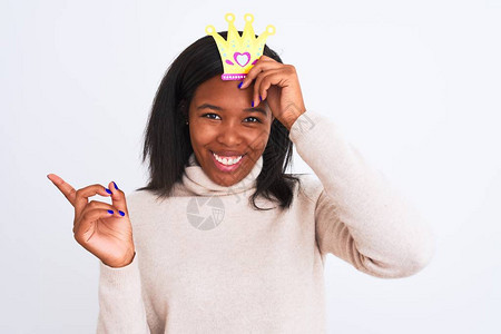 年轻的非洲裔美国女在孤立的背景下戴着假装的王冠图片