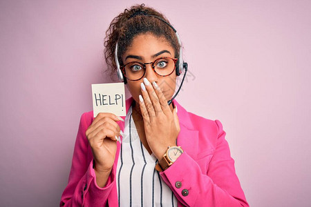 非洲裔美国呼叫中心代理女孩使用耳机手持提醒和帮助信息用手捂住嘴图片