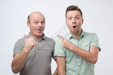 父亲和儿子在自由空间白色工作室背景用手对着图片