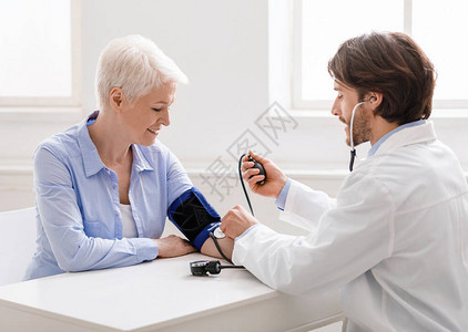 初级医疗检查在门诊部测量高龄妇女血压的图片