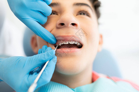 拉丁美洲少年男孩有牙医调整牙套图片