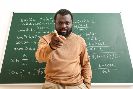 愤怒的非裔美国人数学老师在教室黑板图片