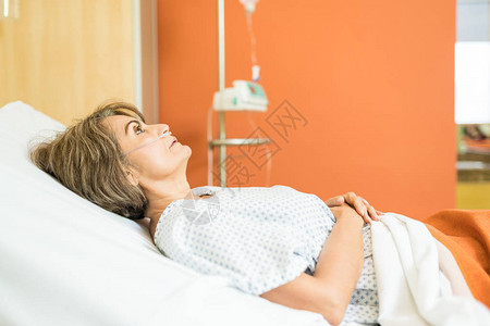 女病人躺在医院床上等待医生时的侧面视线请看女图片