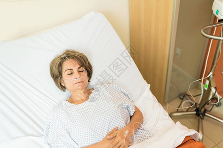 高角度观察在医院床上躺着时身穿鼻腔cannuula的患病女图片