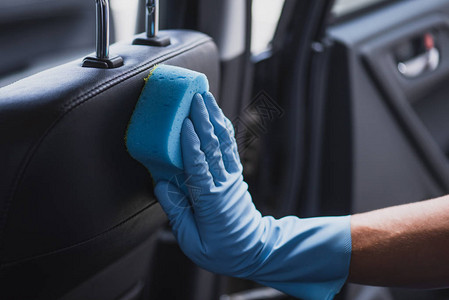橡胶手套擦洗汽车座椅中的汽车清图片