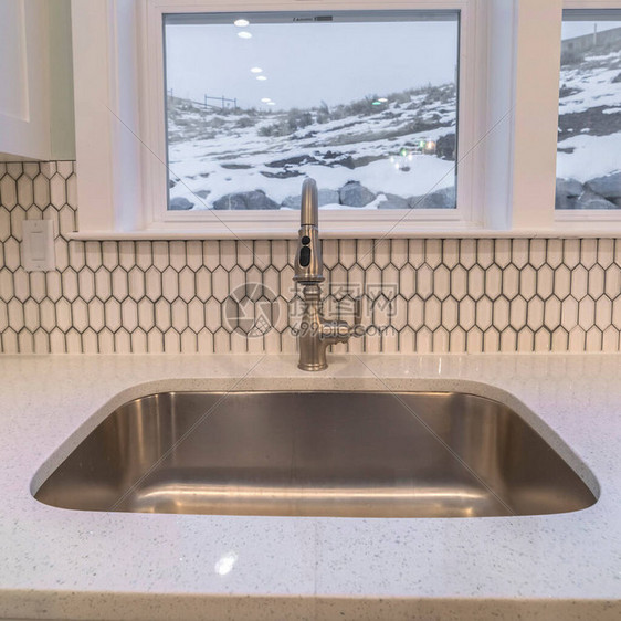 一个现代厨房的不锈钢水槽在双窗下望着图片