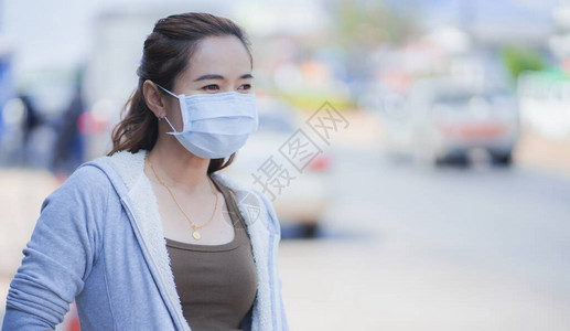 戴着口罩保护在城里行走的亚洲女图片