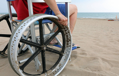 海边推轮椅的男子图片