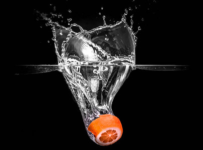 喷水摄影在黑背景下从水中掉落的橙子果图片