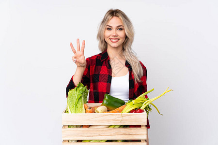 农民女孩拿着一篮子新鲜蔬菜在孤立的白种背景上欢乐快数图片