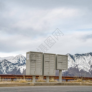 方形框架选择焦点邮箱在雪山和多云天空的道路旁群集邮箱具有图片