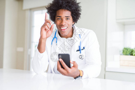 在诊所使用智能手机的非裔美国医生男子对一个想法或问题感到惊讶图片