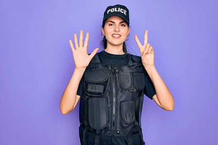 身穿紫色背景外衣安全防弹背心的年轻女警察带着7号指着手指图片