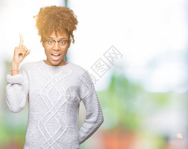 美丽的非洲年轻女穿着冬毛衣与世隔绝的背景指向成功的点子退出并快乐图片