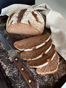 自制黑麦面包分在黑色烤盘上面包图片