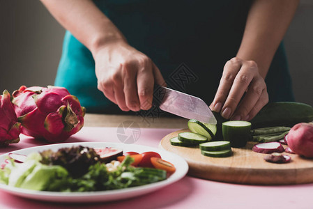 切菜准备做素食沙拉的女人图片