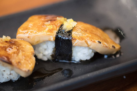 黑盘上的烤鹅肝寿司日式食物图片