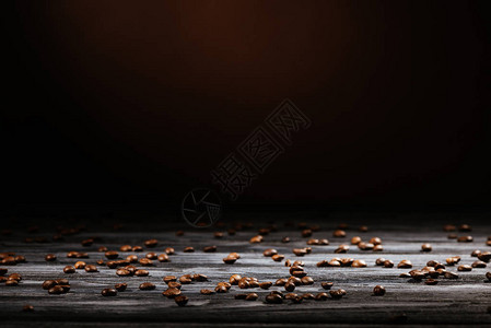 质朴的木桌洒满黑色的咖啡豆图片