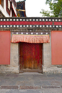 青海省西宁市湟中县藏传佛教寺院塔尔寺库姆寺的复古木门和墙壁图片