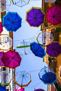 在撒丁岛小镇的一条街道上挂雨伞图片