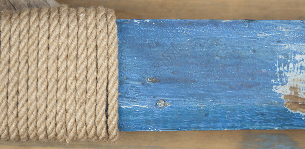 粗麻绳的特写镜头旧木桌上的天然绳索侧图片
