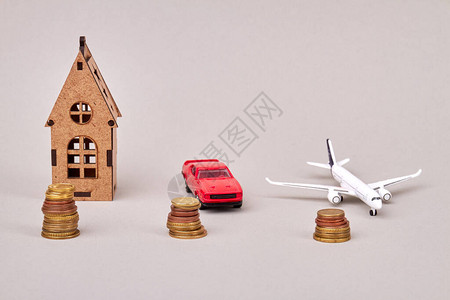 房屋汽车和飞机成本概念房子汽车和飞机模型与成堆的硬图片